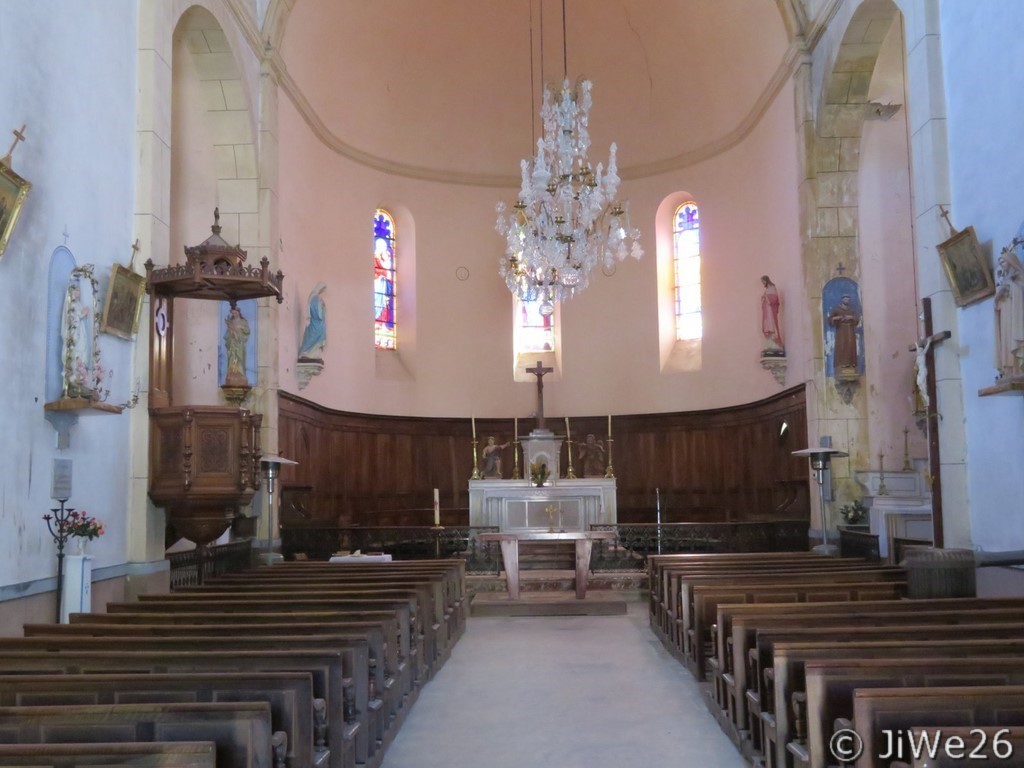Choeur de l'église, vitraux avec images, statue de Marie à gauche et Jésus Christ à droite. On peut apercevoir sur l'autel 2 anges adorateurs