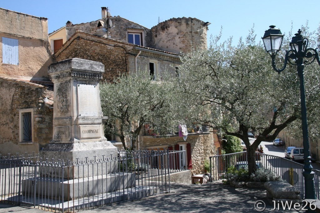 A droite, on aperçoit la tour circulaire au fond et devant, le monument aux morts