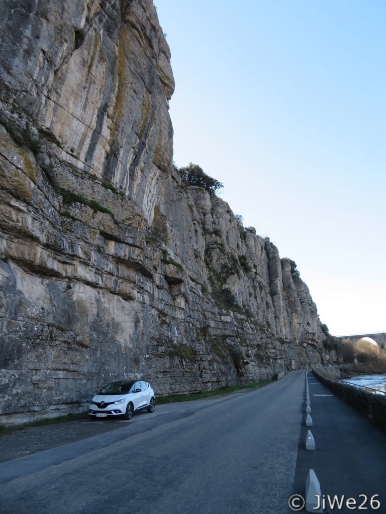 Petit véhicule à côté de l'immense paroi rocheuse