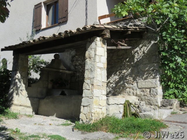 Ici, nous arrivons à l'ancien lavoir en vieilles pierres grises
