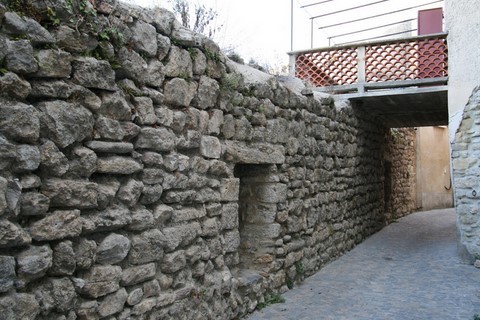 En descendant la rue Basse, voici le mur des remparts avec les meurtrières