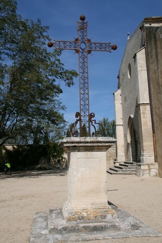 Croix en fer forgé située près de l'église Saint-Luc. Son socle carré est édifié, tout comme l'église, en pierres calcaires blanches des carrières voisines