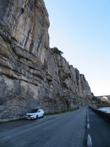 Petit véhicule à côté de l'immense paroi rocheuse